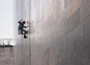 Window cleaner is working on the office building facade